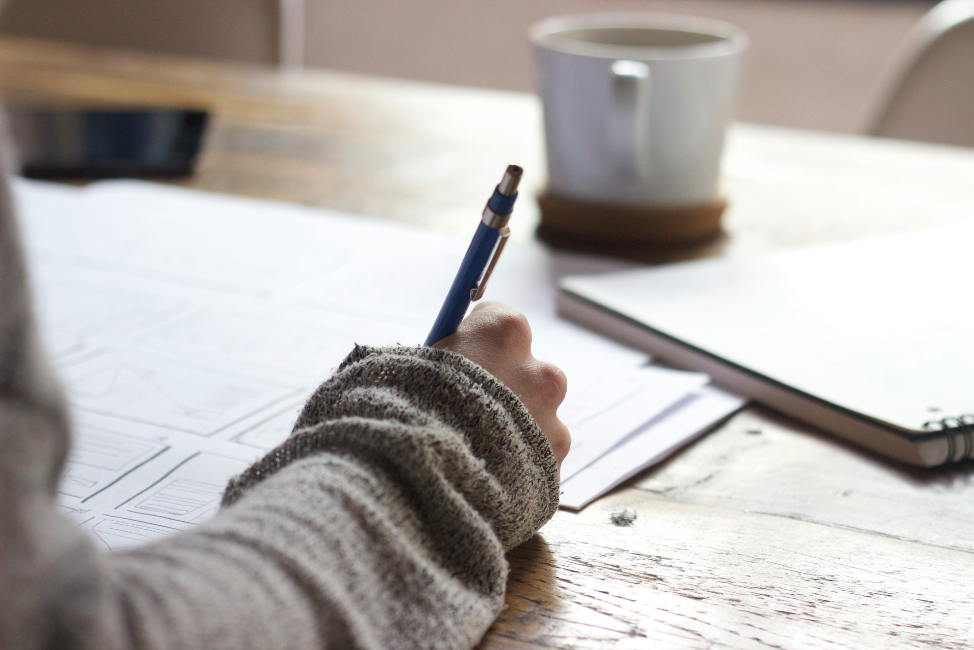 A person writing with a pen